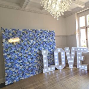 Blue and white flower wall backdrop with 4ft white light up LOVE letters for hire.